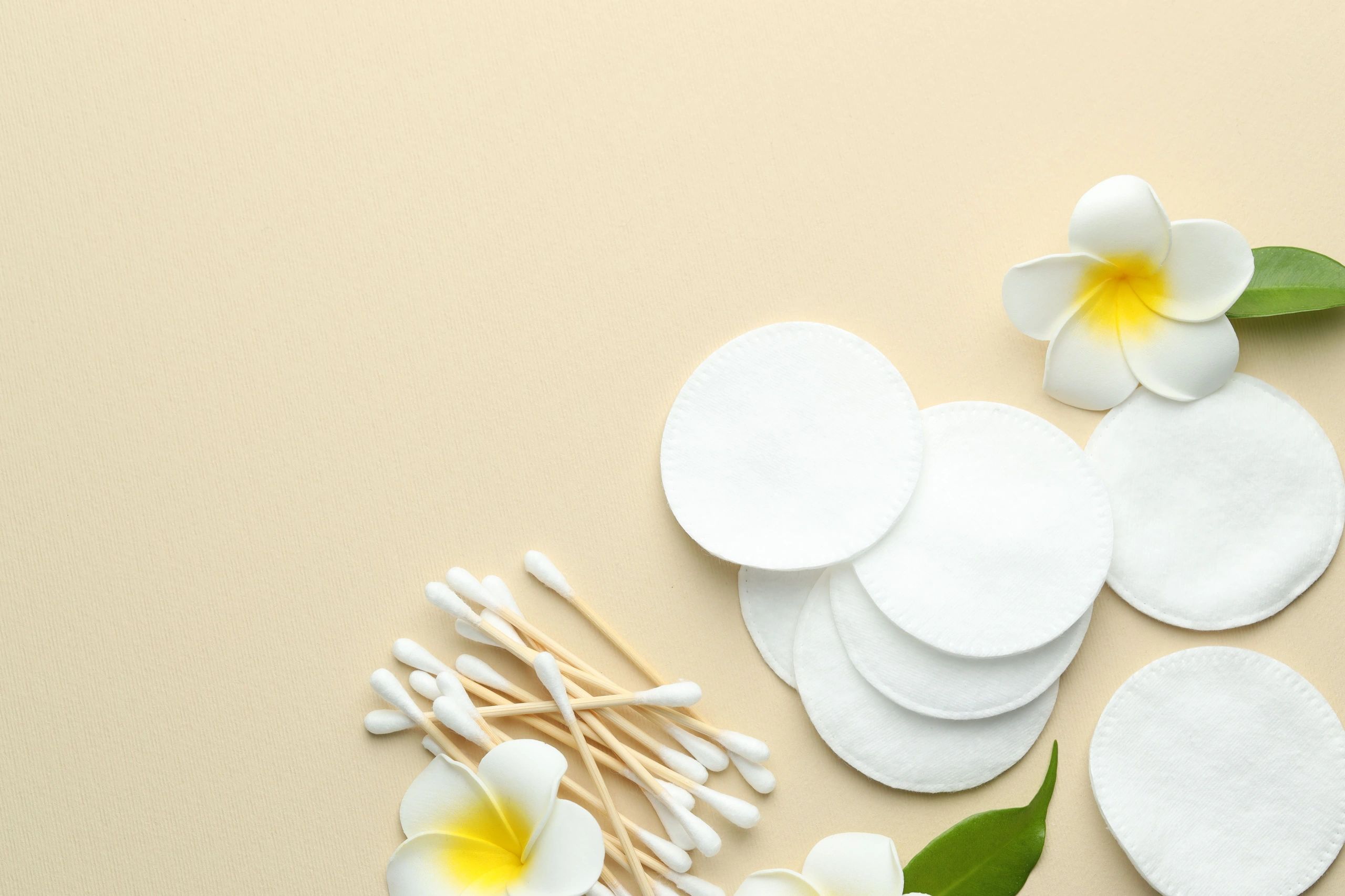 Neutral beauty flat lay with cotton pads and flowers