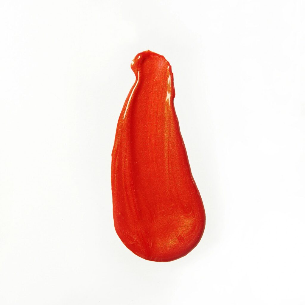 orange smeared lip gloss on white background